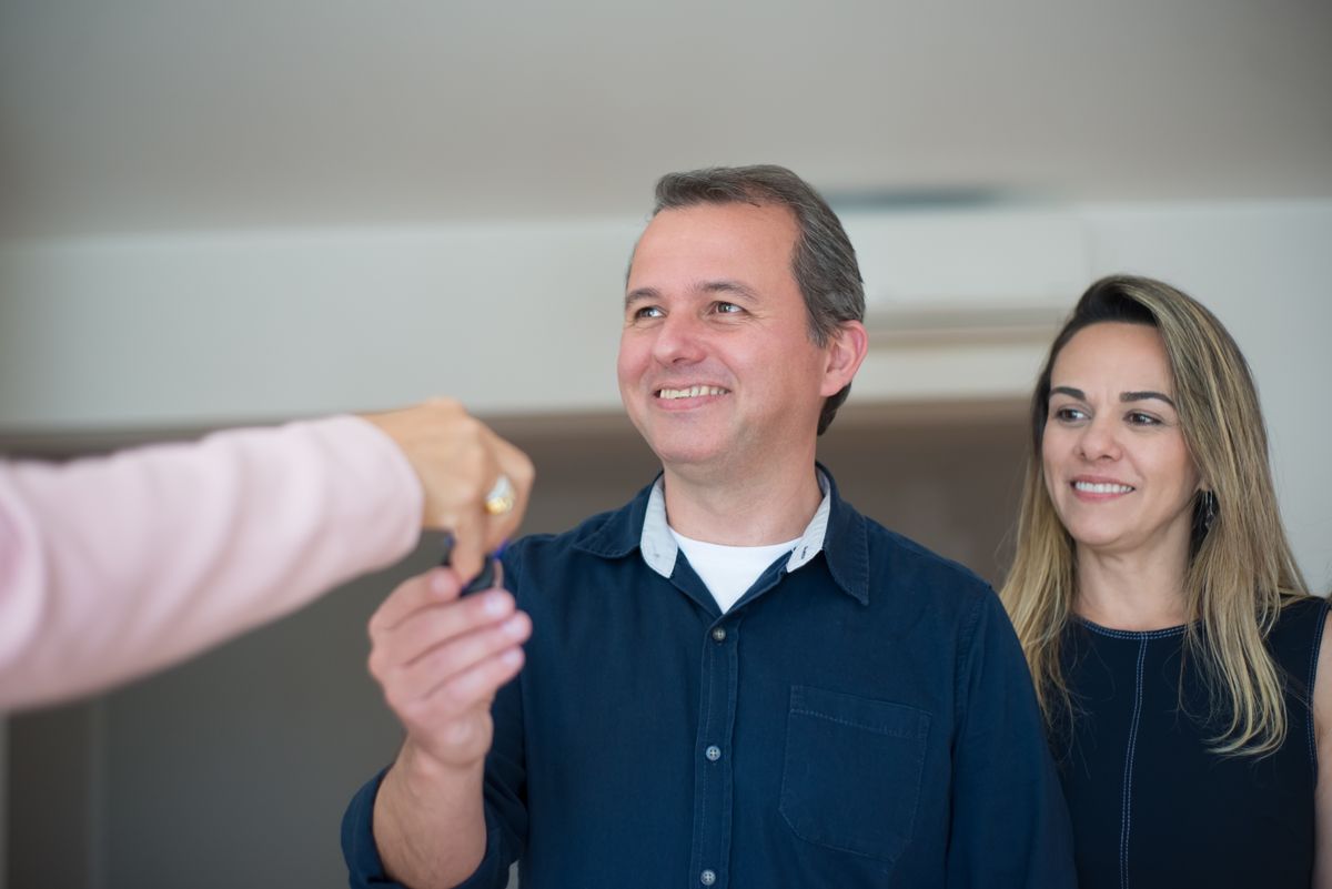 Couple recevant les clés de son logement après la signature d'un prêt immobilier
