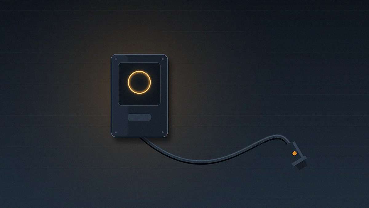 Borne de recharge murale à l’arrêt dans un garage, anneau lumineux orange signalant une anomalie et câble de charge débranché