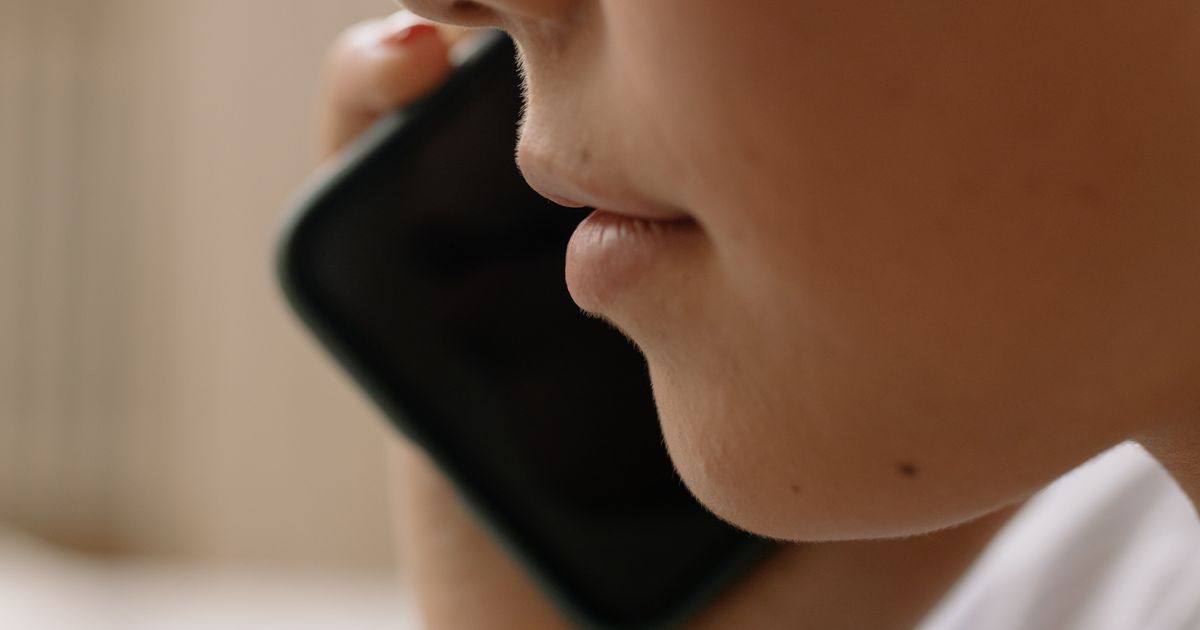 Personne au téléphone tenant un smartphone contre son oreille