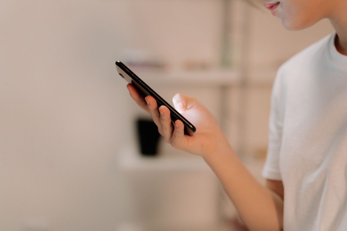 Personne utilisant un smartphone, illustration du choix d'un forfait mobile et de son enveloppe data en 2026