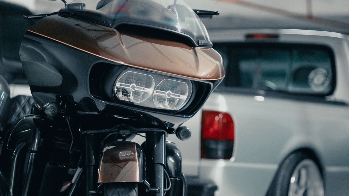 Moto garée dans un garage à côté d'une voiture, en attente de vente